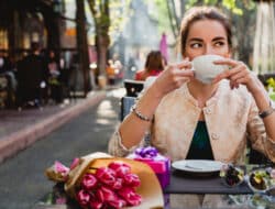 Young woman drinking coffee at an outdoor café in Florence, a perfect setting for studying Italian and experiencing local culture.