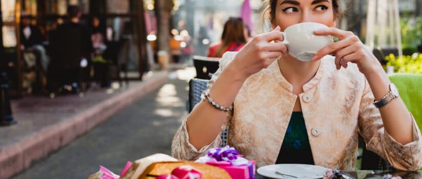 Young woman drinking coffee at an outdoor café in Florence, a perfect setting for studying Italian and experiencing local culture.