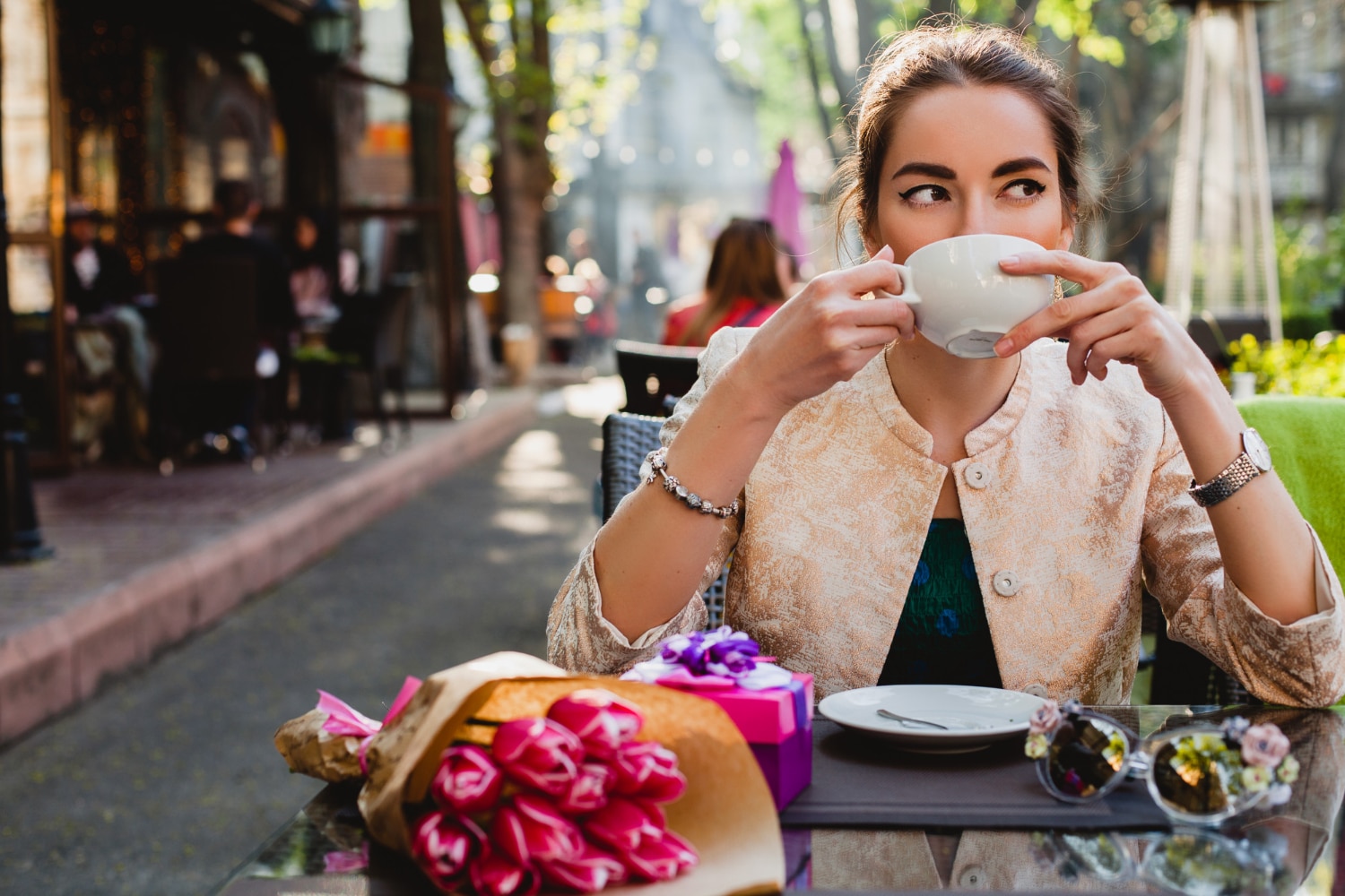 Young woman drinking coffee at an outdoor café in Florence, a perfect setting for studying Italian and experiencing local culture.