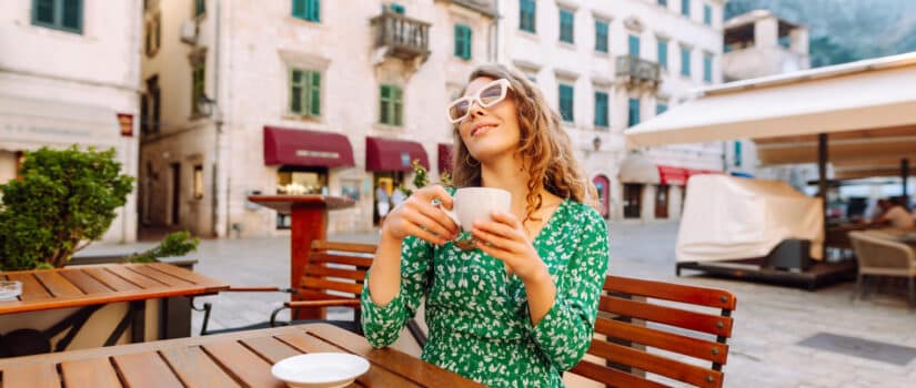 Woman drinking coffee at an outdoor café in a Florentine piazza, symbol of Italian culture and September rituals.